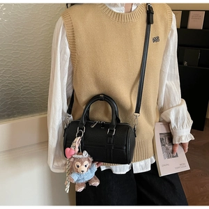 Detail of black Boston bag with cute plush bear charm and adjustable shoulder strap