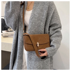 Close-up of brown suede crossbody bag featuring a sparkling peanut-shaped rhinestone buckle
