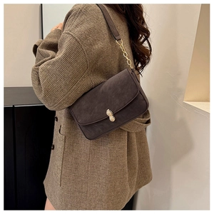 Detail view of a vintage dark brown matte crossbody bag with unique peanut-shaped gold clasp