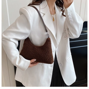 Detail of dark brown faux shearling hobo bag with leather strap and silver metal hardware