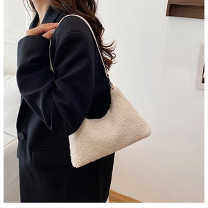 Minimalistische beige Plüsch-Schultertasche zu schwarzem Blazer getragen für Größe
