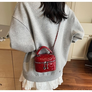 Red quilted box bag with gold chain and heart zipper detail shown on model back