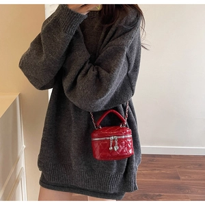 Detail of red quilted mini box bag with silver heart zippers and metal chain strap