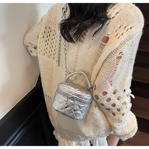 Silver quilted mini box bag with chain strap and heart charm shown on model