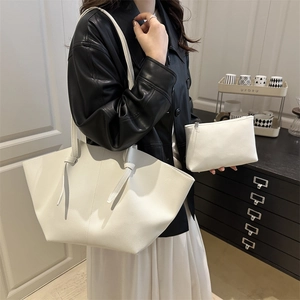 Sac cabas blanc en cuir à motif litchi avec pochette assortie porté par un mannequin