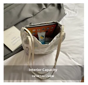 Interior view of white canvas tote bag with blue butterfly print and tassel detail