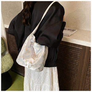 Elegant white satin tote bag featuring detailed butterfly embroidery and pink tassel detail