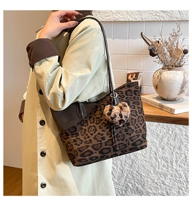 Detail der Leopard-Print-Tasche mit Herzanhänger und braunen Lederriemen für Damen