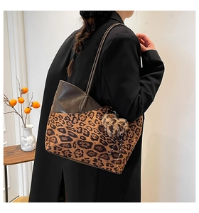 Leopard-Einkaufstasche mit Plüsch-Anhänger und Ledergriffen getragen von einem Model
