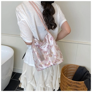 Close-up of pink butterfly print satin tote bag with elegant long silk tassel accessory