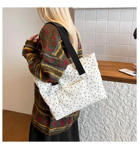 Close-up of white corduroy tote bag with heart and bow prints and FASHION label