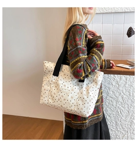 Detail of canvas tote bag showing fashion tag and corduroy bow heart print pattern