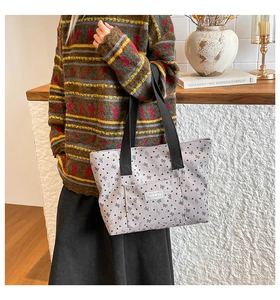 Detail of floral canvas tote bag featuring bow patterns and woven ribbon handle