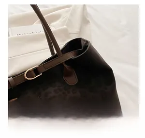 Close-up of leopard print tote bag showing matte texture and gold hardware details
