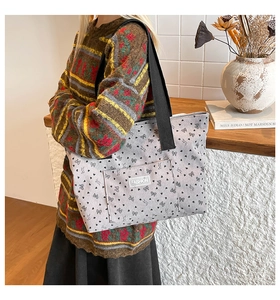 Detail of light grey corduroy tote bag with black ribbon and puppy print patterns