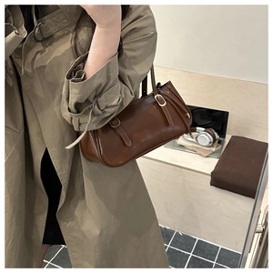 Retro brown leather shoulder bag detail with twin buckle straps and textured finish