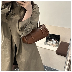 Mirror selfie showing the retro brown leather underarm bag with golden buckles for women
