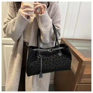 Close-up of leopard print tote bag with plush texture and decorative gold buckle detail
