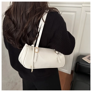 Close-up of white leather underarm bag with gold buckle on model with minimalist background