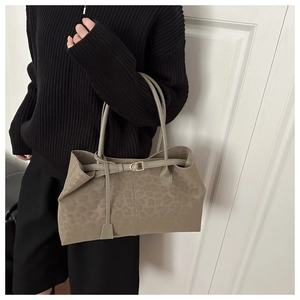 Detail of khaki leopard print tote bag with suede texture and elegant gold hardware