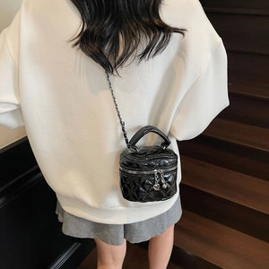Classic black quilted mini box bag with silver chain strap shown on a model