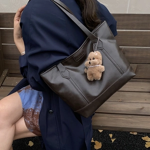 Retro dark brown large tote bag with teddy bear charm shown in a lifestyle setting