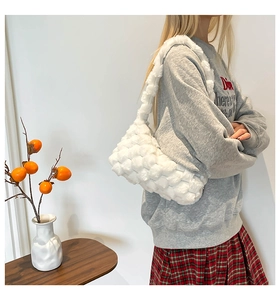 Detail of white plush woven crossbody bag on model with soft autumn aesthetic styling