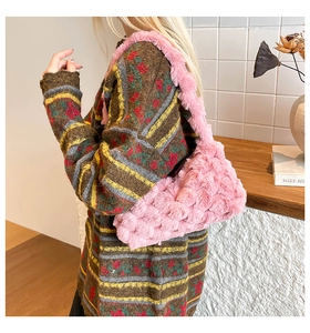 Detail of pink faux fur shoulder bag worn with a floral vintage knit sweater