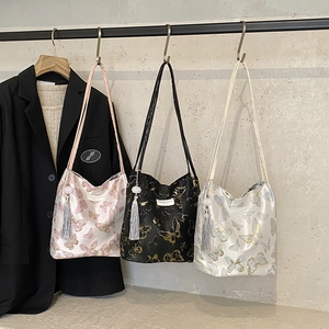 Trois sacs cabas élégants avec broderies papillons et pompons en rose, noir et beige clair