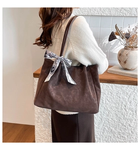Detail of dark brown tote bag with vintage patterned scarf on the handle