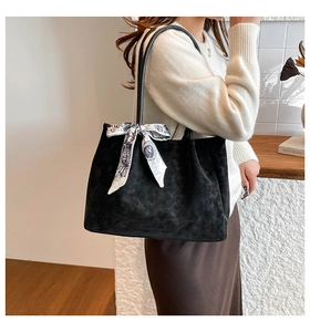 Detail of black suede tote bag with a decorative black and white patterned silk scarf accent