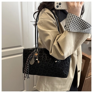 Détail d'un sac cabas léopard avec texte fashion et pendentif de raquette de tennis