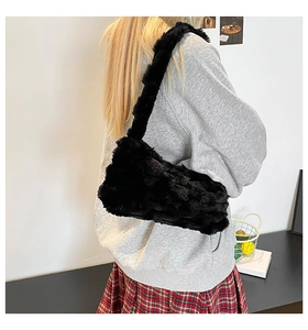 Detail of black faux fur shoulder bag worn by model, fluffy winter commuter crossbody style