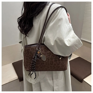 Détail du sac cabas léopard avec breloque raquette dorée et accessoire de nœud en corde