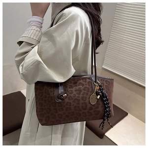 Détail du sac cabas léopard avec logo Fashion en métal et pendentif raquette