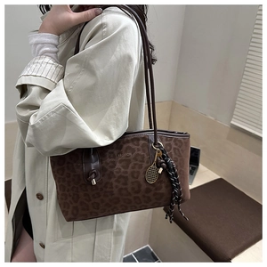 Détail du sac cabas léopard avec texte FASHION et breloque raquette de tennis dorée
