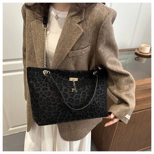 Dettaglio della borsa tote leopardata con ciondolo a cervo dorato e catena