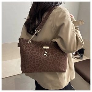 Detail of leopard print tote bag with metal deer pendant and elegant chain strap