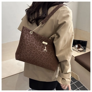 Dettaglio borsa tote leopardata con pendente a cervo dorato e tracolla a catena fine