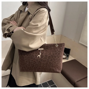 Détail du sac cabas léopard avec pendentif cerf doré et bandoulière en chaîne