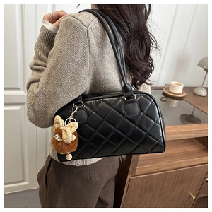 Close-up of black quilted leather bowling bag with a cute brown plush bunny charm