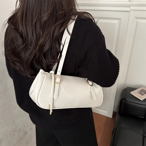 Minimalist creamy white leather shoulder bag with chic gold buckles shown on a model