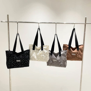 Minimalist butterfly polka dot tote bag in four colors hanging on a metal rack