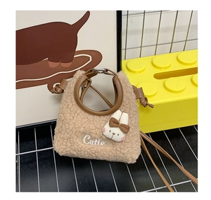 Detail der beige Plüsch-Beuteltasche mit Rundgriff und niedlichem Hasenanhänger