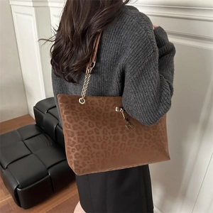 Sac cabas léopard marron avec chaîne dorée et pendentif cerf porté par mannequin