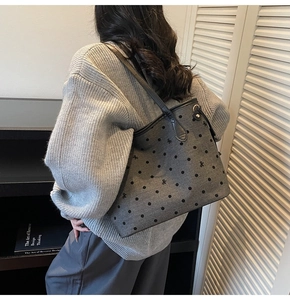 Close-up of grey polka dot tote bag with bow jacquard texture and black shoulder strap