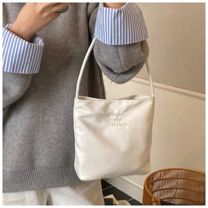 Detalle de bolso de hombro blanco con bordado 'Hope and future' en ambiente cotidiano