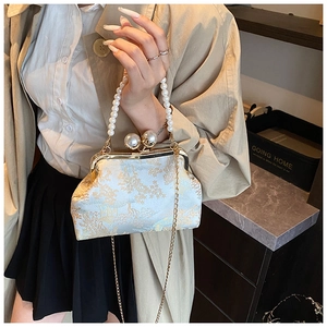 Detail of vintage beaded pearl handle and gold floral brocade on shell-shaped purse