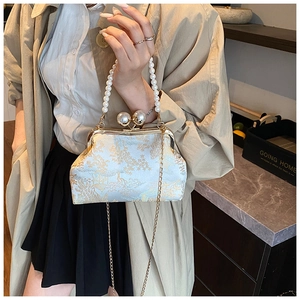 Detail of vintage floral embroidery on cream satin clutch with pearl handle and chain