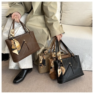 Detail of PU leather tote bag with asymmetric zipper pocket and printed silk scarf handle